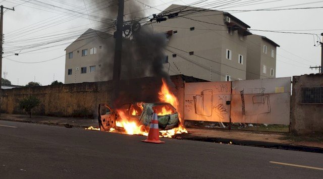 Carro pega fogo após motorista perder controle da direção e derrubar poste.