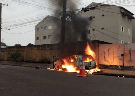 Carro pega fogo após motorista perder controle da direção e derrubar poste.