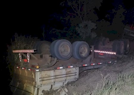 Ao desviar de buraco, caminhoneiro que carregava carga de soja capota na BR-267