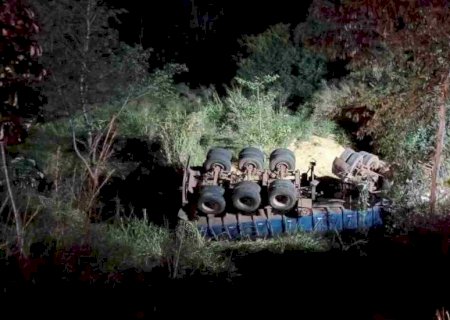Motorista morre após invadir pista contrária e cair com carreta em ribanceira.
