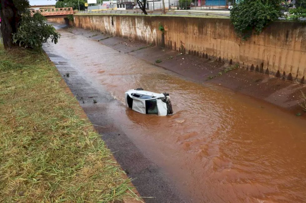 Carro fica destruído ao cair em córrego e três pessoas são socorridas