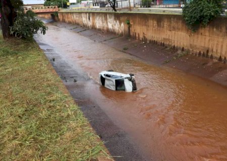 Carro fica destruído ao cair em córrego e três pessoas são socorridas
